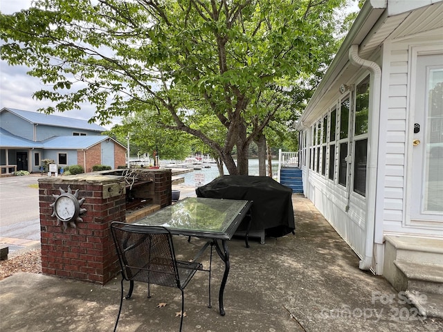 view of patio featuring a water view and area for grilling