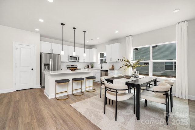 dining area with light wood-style floors, recessed lighting, and baseboards