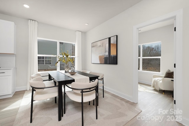 dining room featuring baseboards, recessed lighting, and light wood finished floors