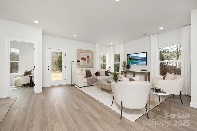 living room with baseboards, recessed lighting, and light wood finished floors