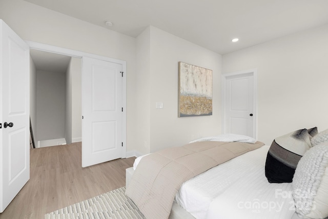 bedroom with baseboards, light wood-type flooring, and recessed lighting