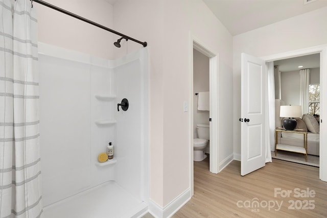 full bathroom with wood finished floors, a shower stall, toilet, baseboards, and visible vents