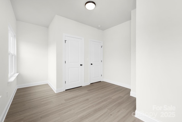 unfurnished bedroom featuring baseboards and light wood-type flooring