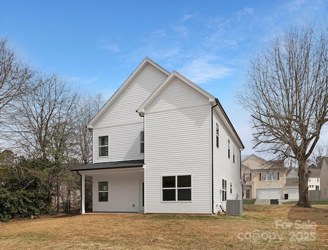 back of house featuring a yard and central AC unit