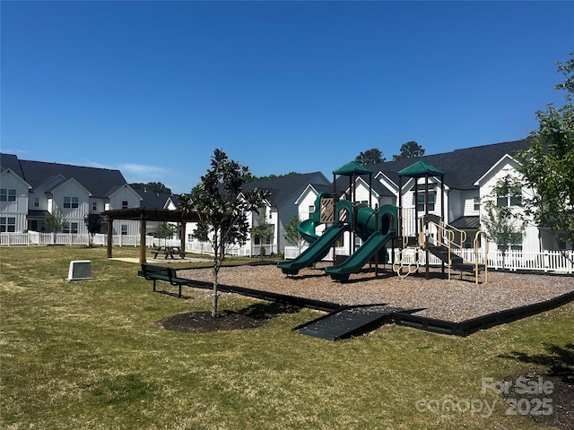 community playground featuring fence, a residential view, and a lawn