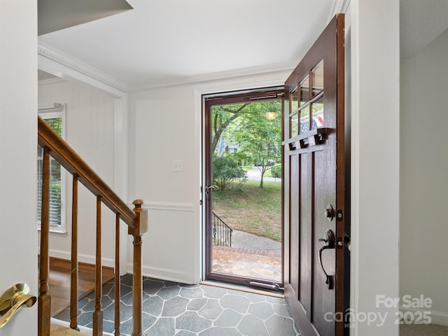 entryway featuring stairs and ornamental molding