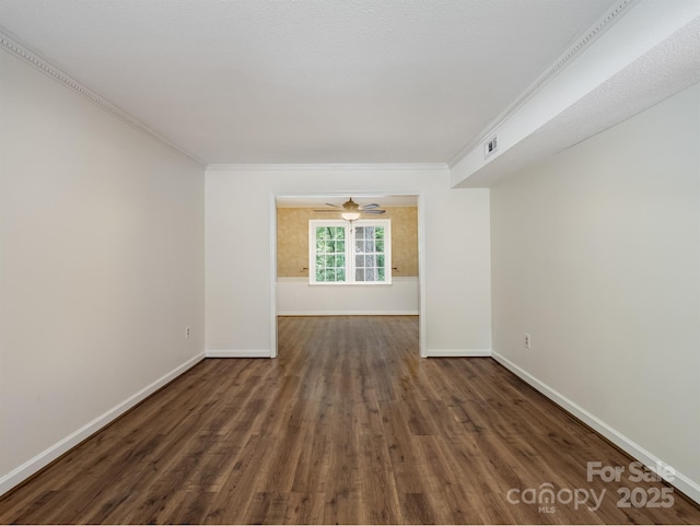 spare room with wood finished floors, baseboards, crown molding, and a ceiling fan