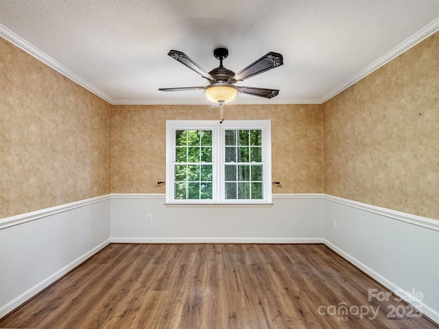 spare room with wood finished floors, a textured ceiling, ceiling fan, ornamental molding, and baseboards