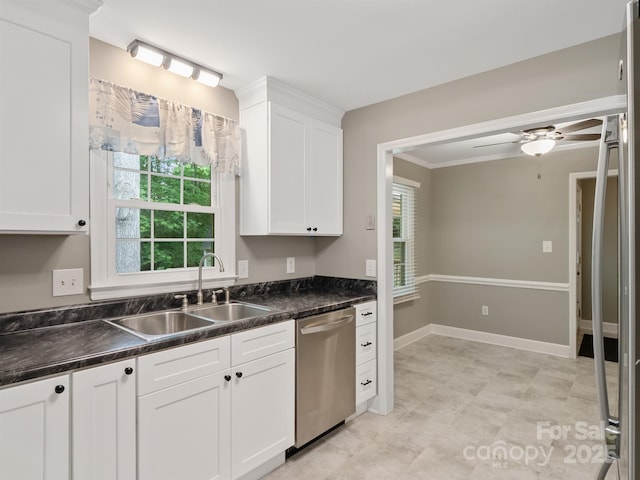 kitchen with stainless steel dishwasher, a sink, dark countertops, white cabinets, and a ceiling fan