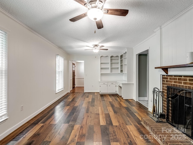 unfurnished living room featuring crown molding, a textured ceiling, a ceiling fan, dark wood-type flooring, and a fireplace