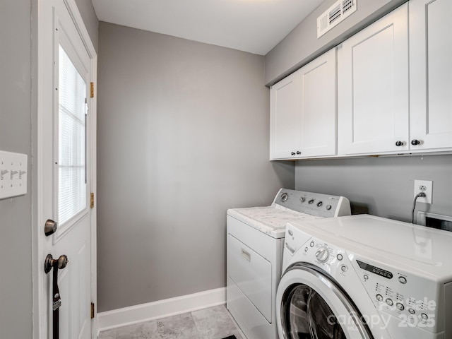 laundry area with cabinet space, washing machine and dryer, and baseboards