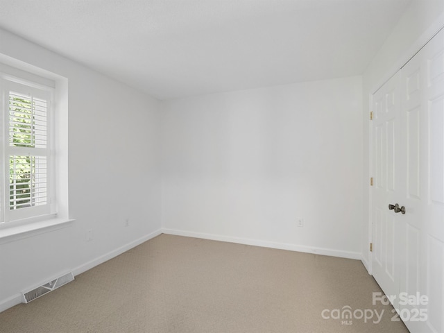 carpeted empty room with baseboards