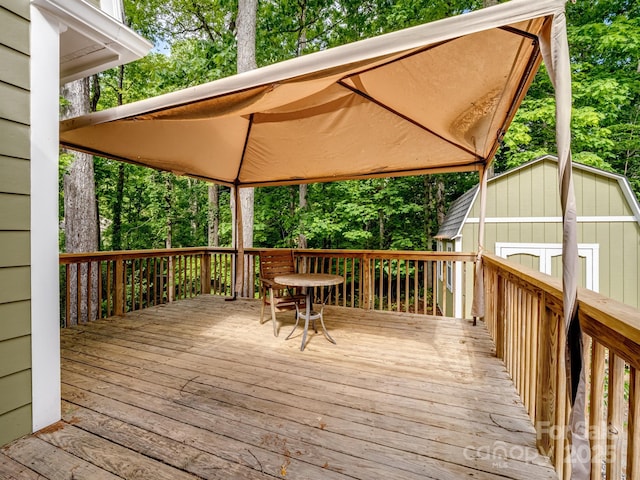 deck with a gazebo and view of scattered trees