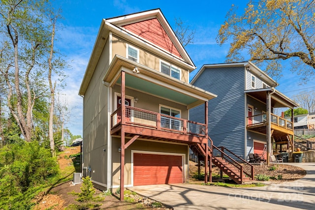 view of front of property with covered porch, driveway, stairs, and a garage
