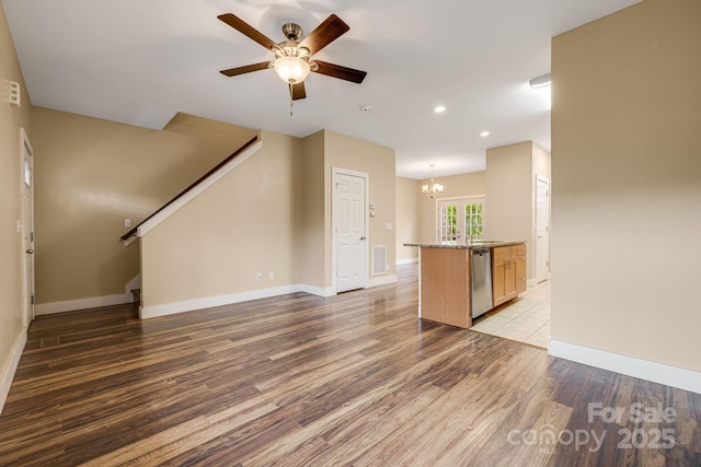 unfurnished living room featuring ceiling fan with notable chandelier, stairs, recessed lighting, wood finished floors, and visible vents