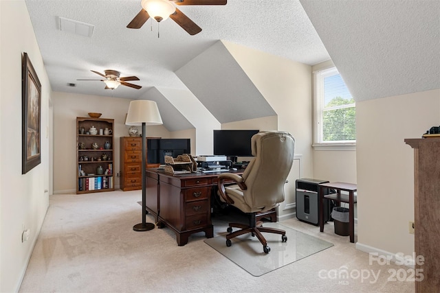 office with lofted ceiling, a textured ceiling, light colored carpet, ceiling fan, and visible vents