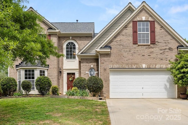 traditional-style house featuring a front yard, driveway, an attached garage, and brick siding