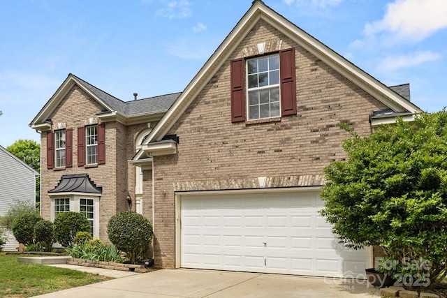 traditional-style house featuring a garage, brick siding, and concrete driveway
