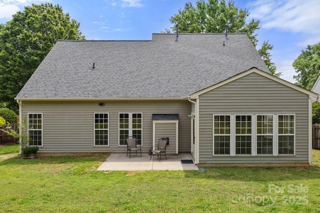 rear view of house featuring fence, a lawn, and a patio