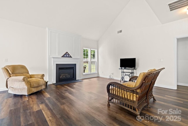 living room with visible vents, baseboards, high vaulted ceiling, and dark wood finished floors