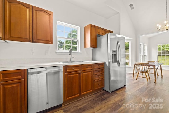 kitchen with dark wood finished floors, stainless steel appliances, light countertops, and a sink