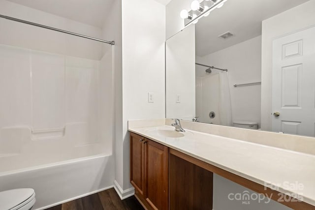 full bath featuring shower / tub combination, wood finished floors, visible vents, and toilet