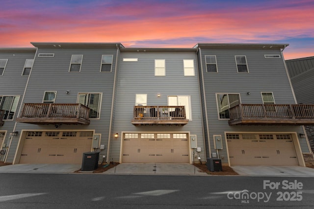 rear view of property featuring a garage and central AC