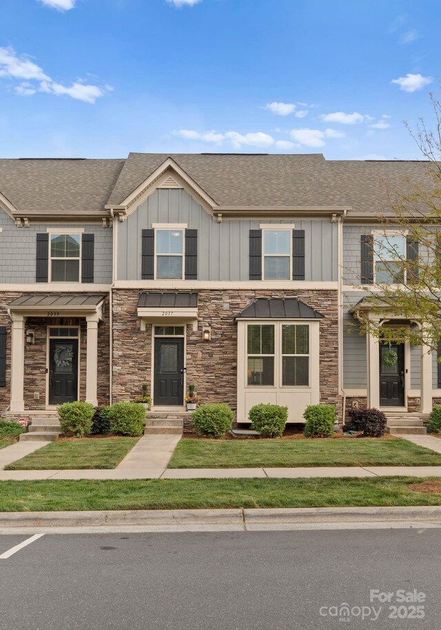 multi unit property with stone siding, board and batten siding, and a shingled roof