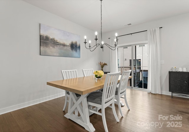 dining space with a chandelier, wood finished floors, and baseboards