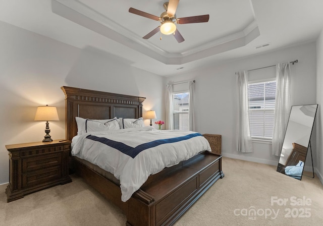 bedroom with ornamental molding, a raised ceiling, light carpet, and visible vents