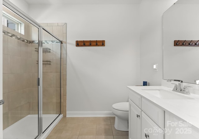 bathroom with toilet, tile patterned floors, baseboards, a shower stall, and vanity