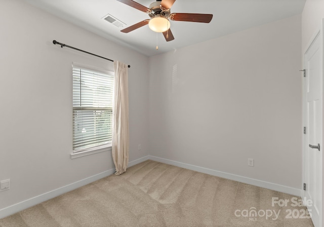 empty room featuring ceiling fan, light carpet, baseboards, and visible vents