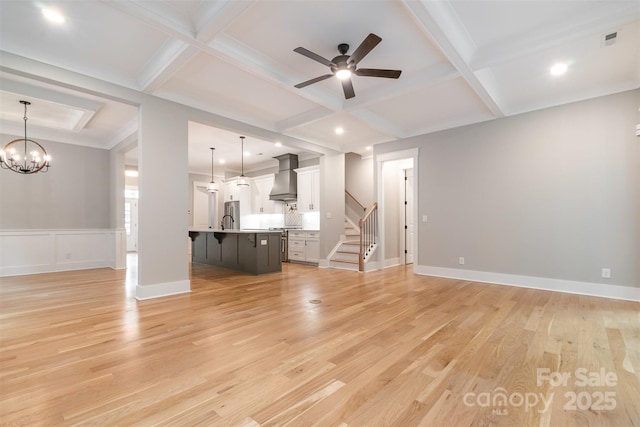 14119 Shelburne Village Dr, Charlotte, NC 28278 - unfurnished living room featuring a sink, stairway, coffered ceiling, light wood-type flooring, and ceiling fan with notable chandelier