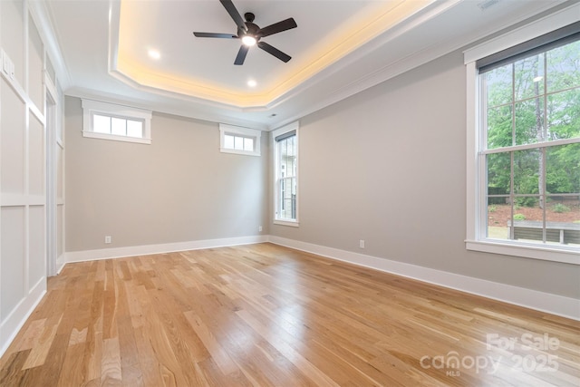 14119 Shelburne Village Dr, Charlotte, NC 28278 - unfurnished room featuring a raised ceiling, baseboards, ornamental molding, light wood finished floors, and a ceiling fan