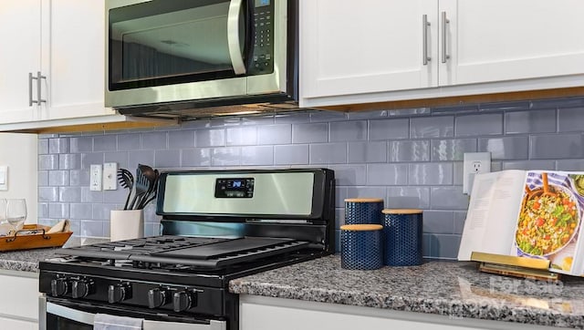 kitchen featuring stone counters, white cabinetry, appliances with stainless steel finishes, and decorative backsplash