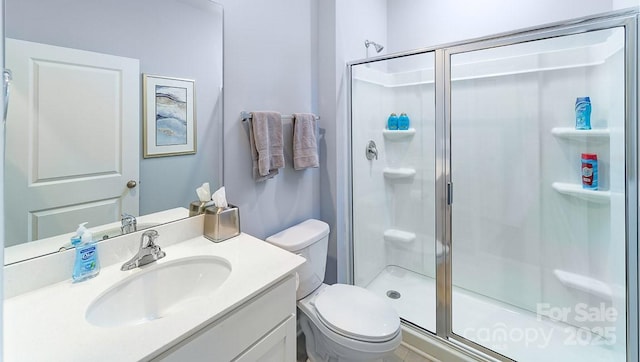 full bathroom with vanity, a stall shower, and toilet