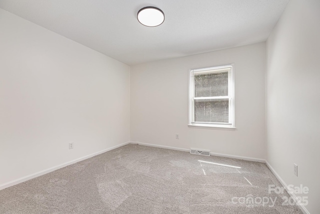 unfurnished room featuring visible vents, carpet floors, and baseboards