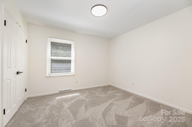 spare room with baseboards and carpet floors