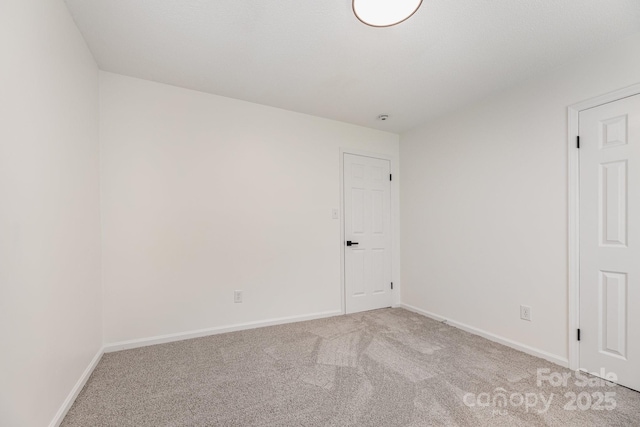 carpeted empty room with baseboards
