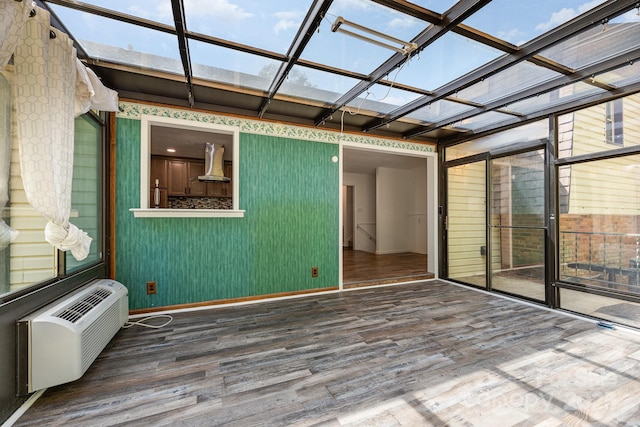 unfurnished sunroom with a wall mounted air conditioner