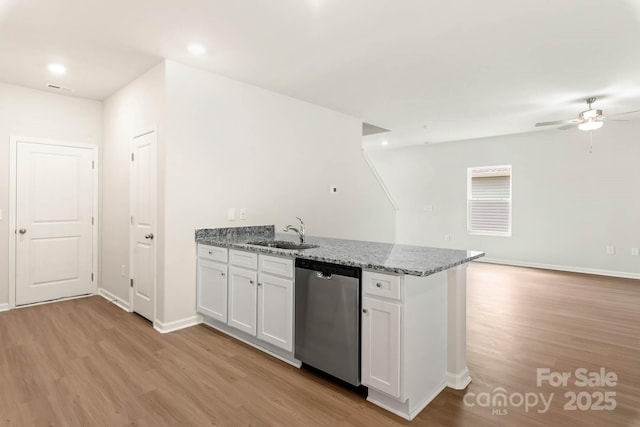 kitchen featuring a sink, light wood-type flooring, a peninsula, dishwasher, and open floor plan
