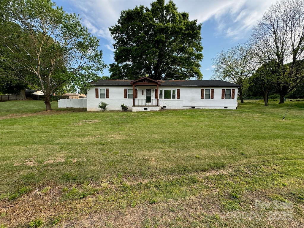 manufactured / mobile home with fence, a front yard, and crawl space