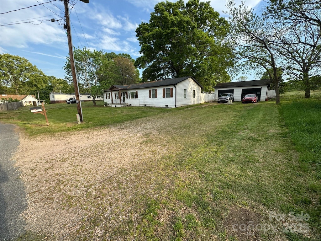 view of yard featuring an outdoor structure, driveway, and a garage