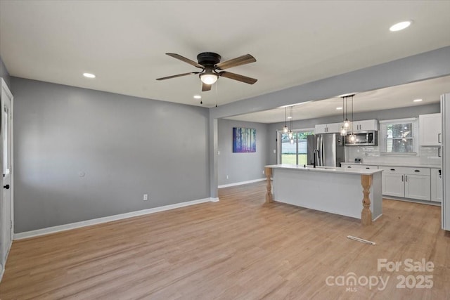 135 Mcshag Dr, Kannapolis, NC 28081 - kitchen featuring light countertops, an island with sink, stainless steel appliances, a ceiling fan, and recessed lighting
