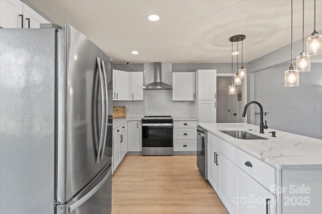 135 Mcshag Dr, Kannapolis, NC 28081 - kitchen with light wood-type flooring, wall chimney exhaust hood, white cabinets, a sink, and stainless steel appliances