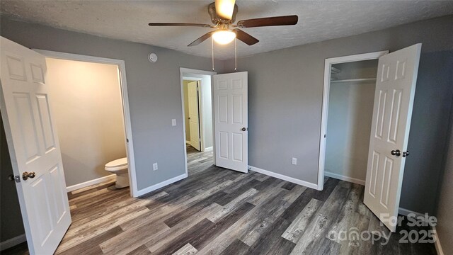 unfurnished bedroom with baseboards, a textured ceiling, dark wood-style flooring, and a closet