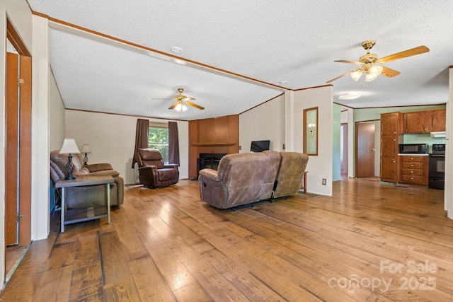 3317 Treyburn Dr, Midland, NC 28107 - living area with crown molding, a fireplace, a textured ceiling, hardwood / wood-style floors, and a ceiling fan
