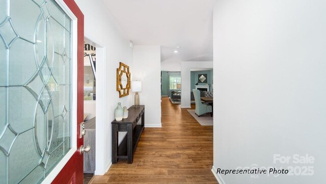 corridor featuring baseboards and wood finished floors