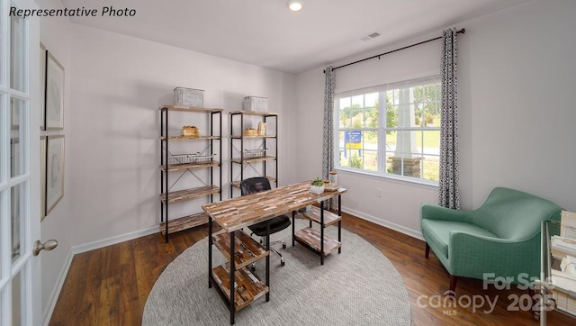 office area featuring baseboards, visible vents, and wood finished floors