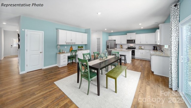 dining space with recessed lighting, baseboards, and dark wood finished floors